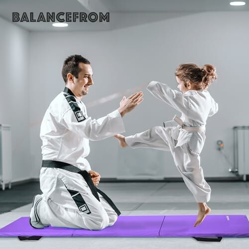 Adult and child practicing martial arts on a purple mat.